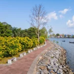 Riverside walkway and local boats beside the Tapee River in Surat Thani city