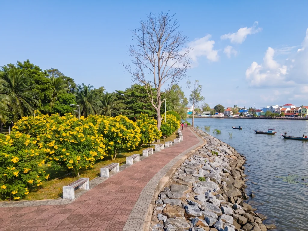 Riverside walkway and local boats beside the Tapee River in Surat Thani city